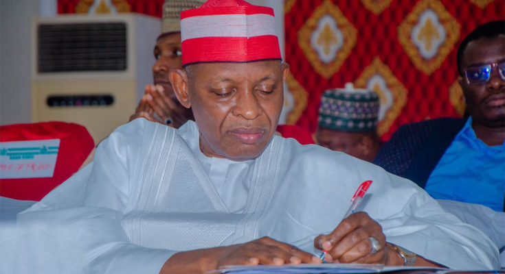 Governor Abba Yusuf signing a document